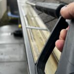 Home Close-up of gutter cleaning with pressure washer, outdoors, during the day.
